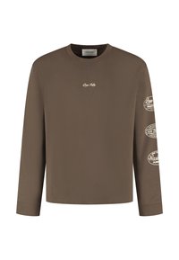 Bruine longsleeve t-shirt van zachte stof met een klein logo op de borst en drie bedrukte etiketten op de rechtermouw.