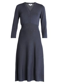 Robe tricotée bleu marine avec un décolleté en V, des manches 3/4 et un ourlet évasé. Dotée d'un corsage ajusté se transformant en jupe fluide.