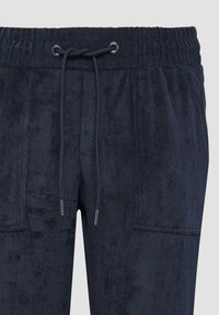 Navyblauwe corduroy broek met een zachte textuur, elastische tailleband en trekkoord. Voorzien van twee voorzakken en een ontspannen pasvorm.