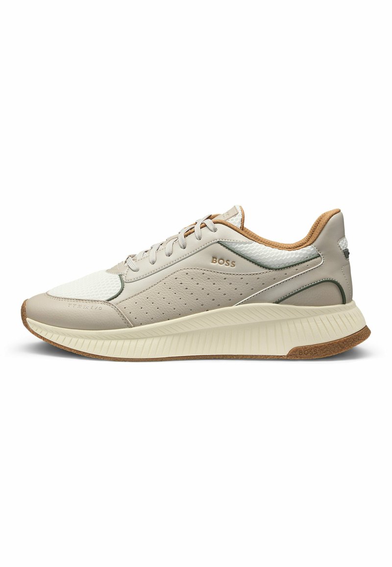 Sneaker beige chiaro con tomaia in pelle e rete, design perforato, dettagli marroni sul tallone e suola in gomma texturizzata. Logo sul lato.