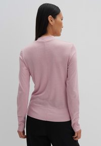 Hellrosa langärmliger Pullover mit rundem Halsausschnitt, strukturiertem Strick, geripptem Saum und glatter Oberfläche. Die Rückansicht zeigt minimale Nähte.
