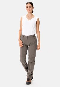 Leichte, knielange, graue Hose mit verstellbarem Bund; kombiniert mit einem ärmellosen weißen Oberteil. Funktionalität geeignet für Aktivitäten.