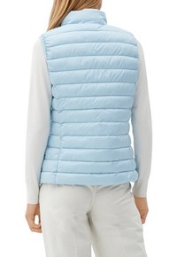 Světle modrá prošívaná vesta s vysokým límcem, zdobená vodorovným prošívaným vzorem a zapínáním na zip, nošená přes bílý dlouhý rukáv.