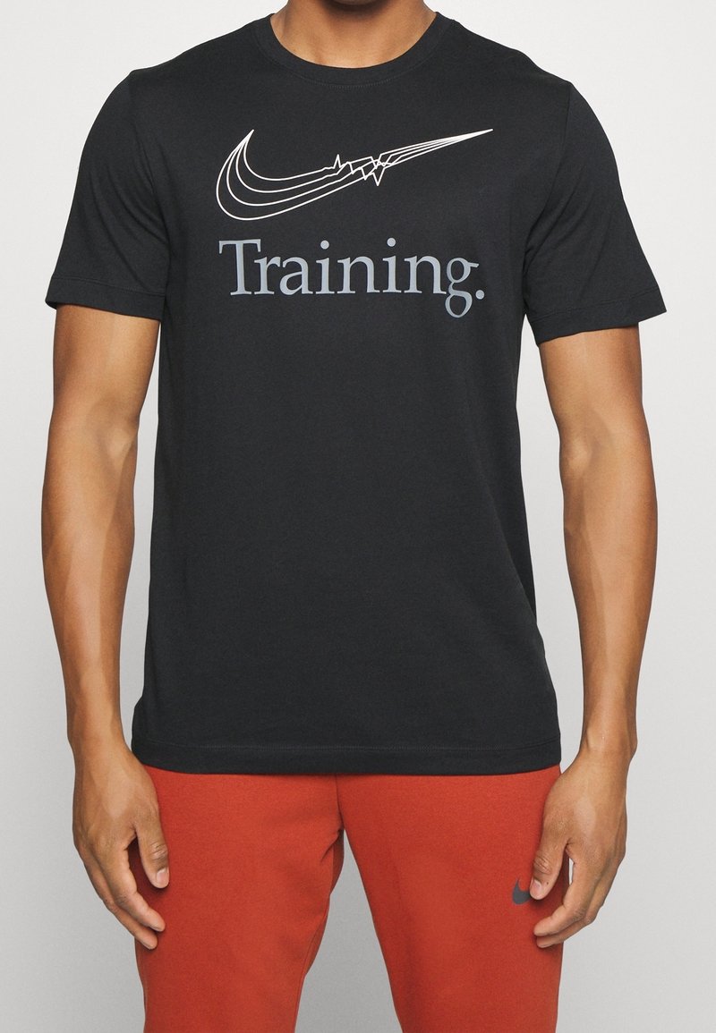 Camiseta de algodón negra con el logotipo blanco de Nike y la palabra "Entrenamiento" en gris, con cuello redondo, mangas cortas y ajuste estándar.