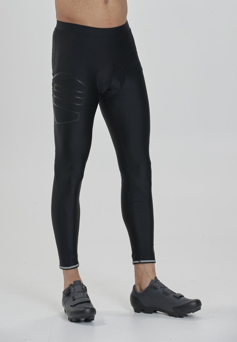 Schwarze Radfahren-Tights aus elastischem Material, mit gepolstertem Schrittbereich und reflektierenden Akzenten entlang des unteren Saums.