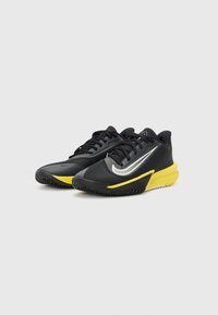 Black athletic shoes with a textured upper, silver accents, yellow midsole, and a patterned rubber sole. Lightweight design for performance.