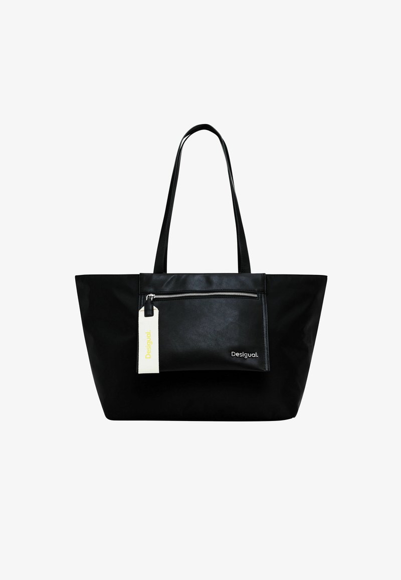 Musta olkalaukku pitkillä kahvoilla, jossa on edessä vetoketjullinen tasku ja valkoinen etiketti. Valmistettu sileästä, matasta materiaalista. Minimalistinen muotoilu.