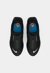 Melni sporta apavi ar rāvējslēdzēju, ar gludu tekstūru, redzamu Air Max logo un zilu iekšzoli ar apļa dizainu.