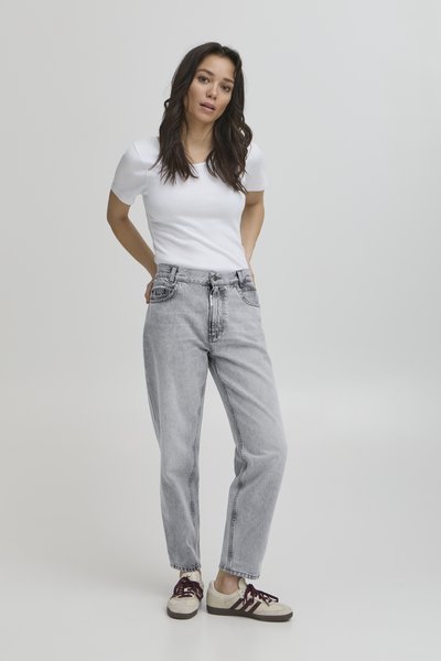 Jeans en denim gris clair à coupe décontractée, dotés d'une taille haute et d'un design à cinq poches. Associés à un T-shirt blanc uni et des baskets beiges.