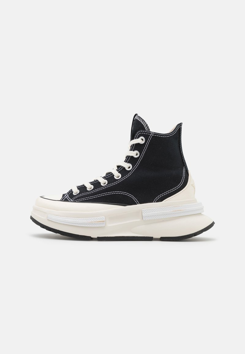 Hoge sneakers van zwart canvas met witte stiksels, voorzien van een stevige witte zool, rubberen neuskap en vetersluiting.