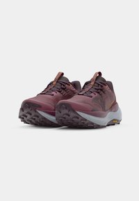 Trail running shoes in maroon, featuring a textured upper, gray midsole with speckles, and rugged outsole for traction. Vibram accent detail.