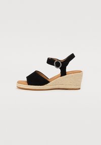 Sandale compensée en suède noir avec un talon en jute de style espadrille, sangle de cheville ajustable avec une boucle ronde en argent.