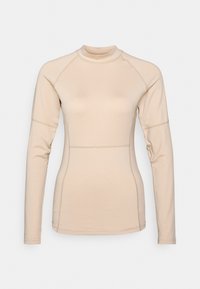 Beige långärmad topp med hög hals, figurnära design och raglanärmar. Tillverkad av ett mjukt material med subtila sömdetaljer.