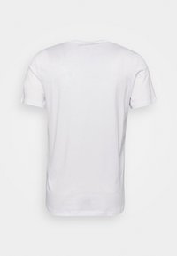 Tricou alb din bumbac, cu mâneci scurte și guler rotund. Spatele are un design simplu, neted, fără imprimeuri sau accente.