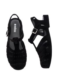 Sandales noires à lanières avec une finition texturée, dotées d'une bride à boucle réglable et d'un design découpé. Intérieur entièrement noir.