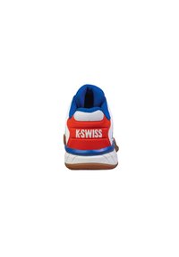 Bílé sportovní boty s modrými akcenty, červenou patou, texturovaným síťovinovým svrškem, logem na patě, gumovou podrážkou, navržené pro pohodlí a výkon.