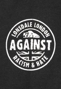 Logo Lonsdale London s řvoucím lvem nad slovem "PROTI" a vlajkou Unie, obklopené textem "Rasismus a Nenávist" na černé látce.