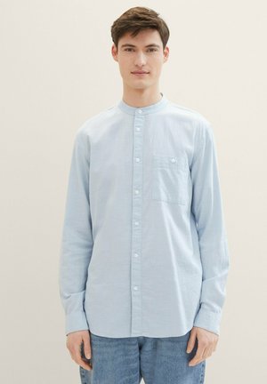Hellblaues Langarmhemd mit Knopfleiste und Mandarin-Kragen, einer Brusttasche und weich, leicht strukturiertem Stoff.