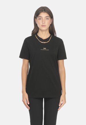 T-shirt nera in cotone con scollo rotondo, maniche corte e un logo dorato al centro. Abbinata a una semplice collana con catena dorata.