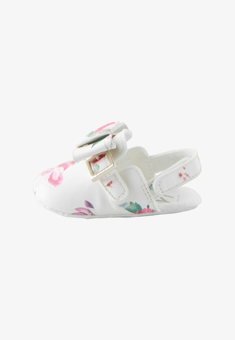 Chaussure de bébé blanche avec imprimé floral rose et vert, nœud avec boucle dorée sur le dessus, et bride arrière pour un ajustement sécurisé.