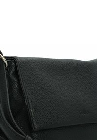 Bolso de hombro de cuero negro con acabado texturizado, que presenta una solapa plegable y un detalle en hardware plateado. Logotipo grabado en la parte frontal.