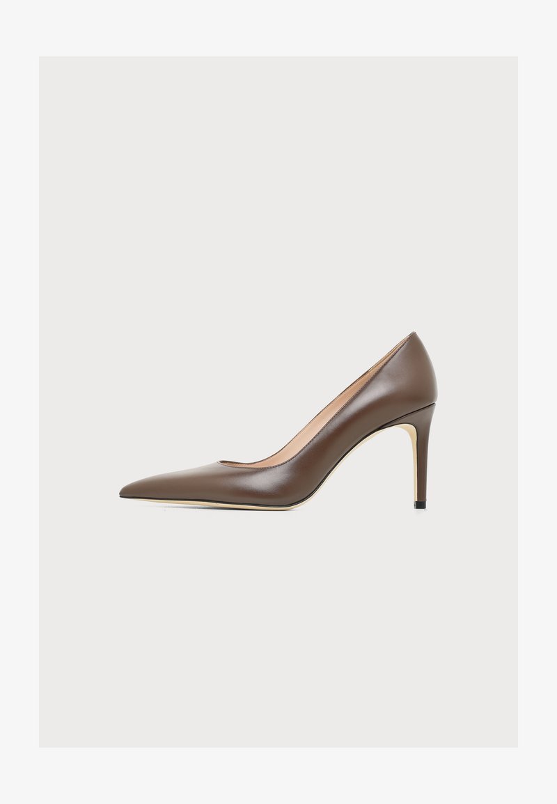 Escarpin en cuir marron à talon haut avec bout pointu et talon fin sur un fond clair uni.