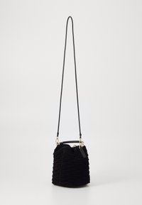 Sac seau en velours noir avec un motif texturé et froncé, quincaillerie dorée, sangle ajustable et base ronde pour la stabilité.
