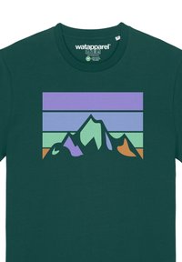 T-shirt en coton vert avec un graphique de montagnes stylisées en violet, vert et orange sur un fond stratifié de rayures pastel.