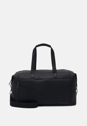 Sac de sport noir en matériau synthétique texturé, doté de poignées doubles, d'une sangle détachable et d'une poche zippée à l'avant.