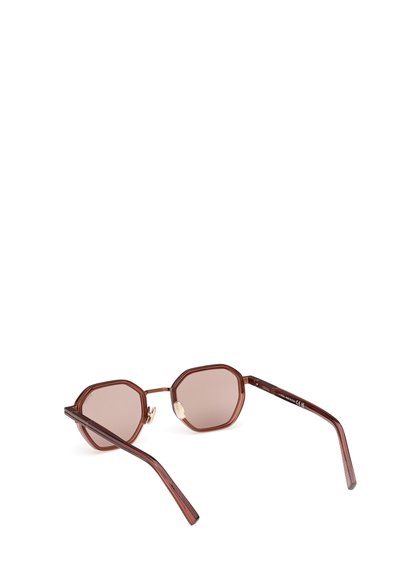 Ochelari de soare octogonali maro cu lentile maro întunecate, rame texturate maro și accente din metal de culoare aurie pe laturi.