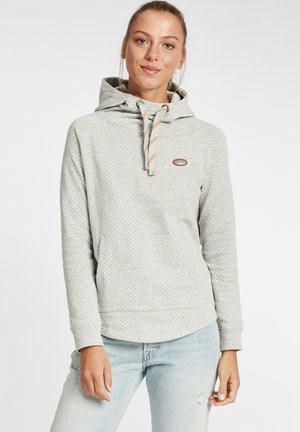 Haut de survêtement gris clair en tissu texturé avec un motif à pois, doté d'une capuche réglable et d'un petit logo à l'avant.