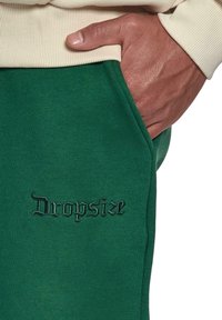 Grønne sweats, der har et broderet "Dropsize"-logo, lavet af blødt materiale med en afslappet pasform og sidelommer.