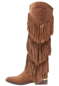 Botas de ante marrón hasta la rodilla que presentan múltiples capas de flecos verticales, una puntera afilada y un tacón bajo apilado. Superficie texturizada evidente.