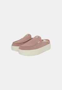 Scarpe slip-on in suede rosa con una spessa suola in gomma bianca, caratterizzate da una punta rotonda e dettagli cuciti sulla parte superiore.