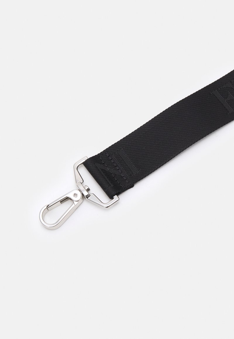 Sangle en nylon noir avec un clip en métal ; surface texturée ; présente des coutures le long de sa longueur ; fonctionnelle pour sécuriser des objets.