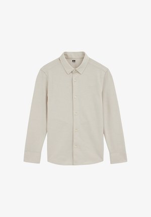 Camicia beige chiaro a maniche lunghe, realizzata in tessuto morbido, con colletto classico, chiusura a bottoni e un piccolo logo sul petto a sinistra.