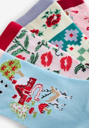 Vier Paar Socken mit verschiedenen Mustern: Blumenmuster, Lippen, geometrische Formen und Illustrationen auf einer Mischung aus pastellfarbenen und lebendigen Hintergründen.