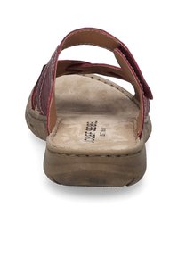 Red leather slide sandal with two overlapping straps, cushioned footbed, and a contoured sole. Interior shows brand label printed on the insole.