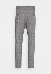 Pantalon à carreaux gris vu de dos avec deux poches passepoilées boutonnées et une coupe slim effilée.