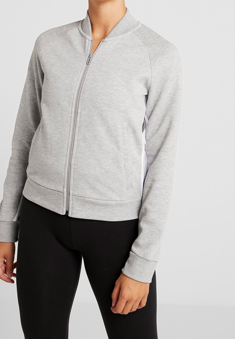 Grå zip-up jakke lavet af blødt stof. Har raglanærmer, ribbede manchetter og to sidelommer. Letvægts med en afslappet pasform.