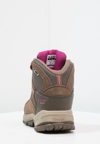 Stivale da hiking impermeabile marrone e grigio con accenti rosa, supporto alto alla caviglia, suola texturizzata e fodera interna imbottita rosa.