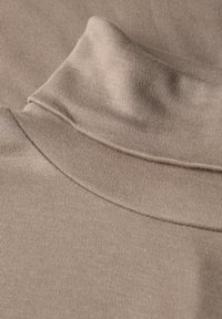 Beiger Baumwollstoff mit hohem, umgeschlagenem Kragen und glatter Textur, der eine subtile Dehnbarkeit und eine engmaschige Webart aufweist.