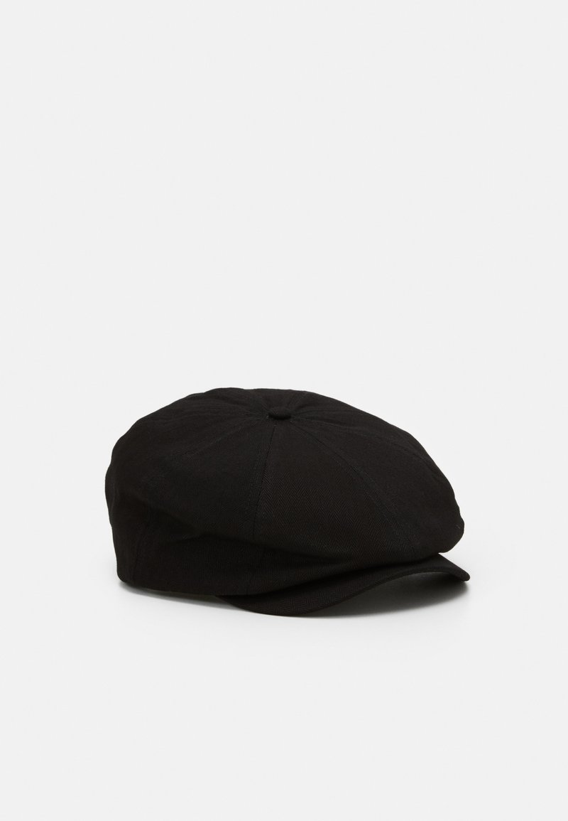 Casquette plate noire avec une petite visière incurvée, en tissu doux, présentée sur un fond clair uni.