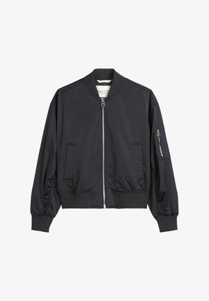 Czarna kurtka bombowa z przednim zamkiem, dwoma bocznymi kieszeniami, ściągaczami przy mankietach i u dołu, oraz kieszenią na zamek na lewym rękawie.