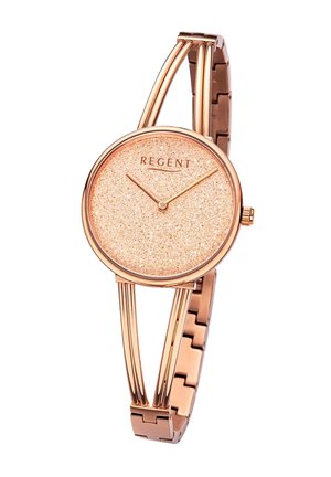 Montre en or rose avec un cadran rose pailleté, bracelet en métal fin avec des bras courbés doubles, et aiguilles des heures et des minutes simples.