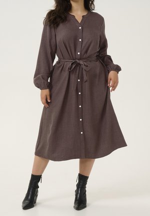 Braunes, langärmeliges Hemdkleid mit tailliertem Bund und strukturiertem Stoff. Verfügt über weiße Knöpfe und eine lässige, fließende Silhouette.