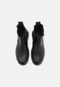 Black leather ankle boots with elastic side panels and pull tab. Smooth texture with a rounded toe and stitched detailing around the sole.