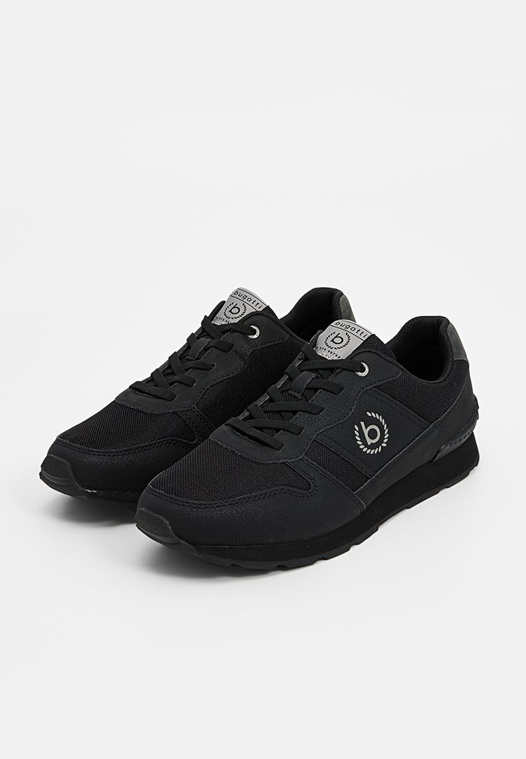 Chaussures de sport noires avec tige en mesh et cuir synthétique, bout rond, détails texturés, lacets noirs et logo sur la languette.