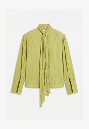 Lys grønn bluse med lange ermer, plissert detaljering, utvidede brede mansjetter og et langt slips som henger ned midt foran.