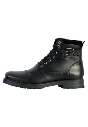 Botte en cuir noir à cheville avec bout rond, lacets sur le devant, accent en boucle métallique et semelle robuste pour une meilleure traction. Présente des panneaux lisses et texturés.